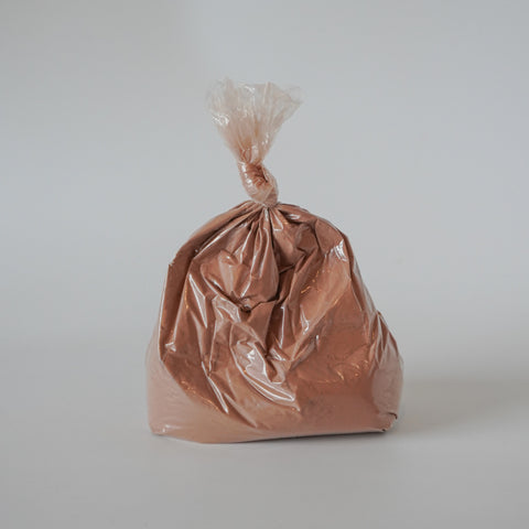 Brown plastic bag tied at the top on a gray background