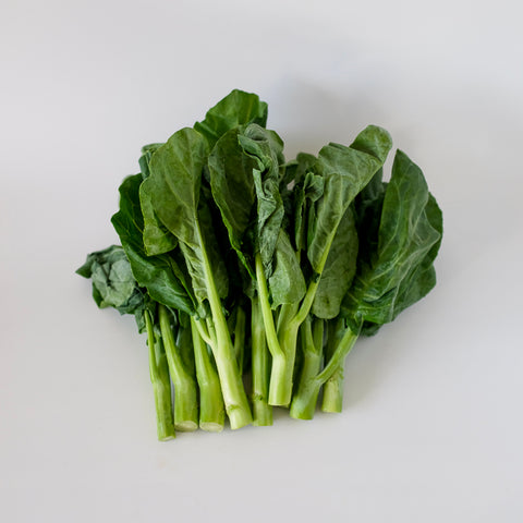 Bunch of green leafy vegetables on a white background