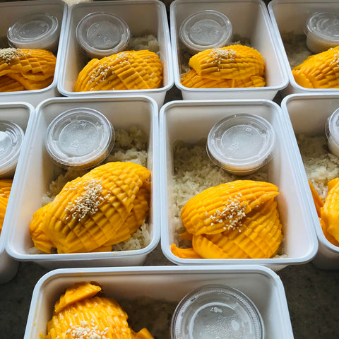Mango dessert in small containers with a lid on a concrete surface