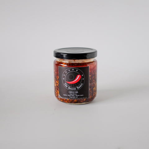 Jar of chili oil with a black label on a white background