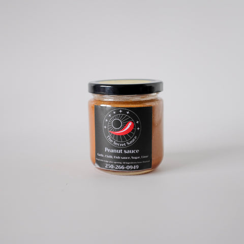 Jar of peanut sauce with a label on a white background