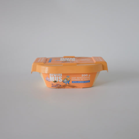 Orange container of truffle hummus on a gray background