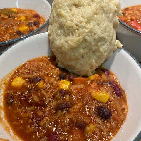 Bowl of chili with a biscuit on top