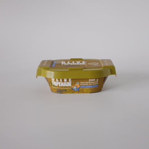 Container of olive tapenade on a gray background